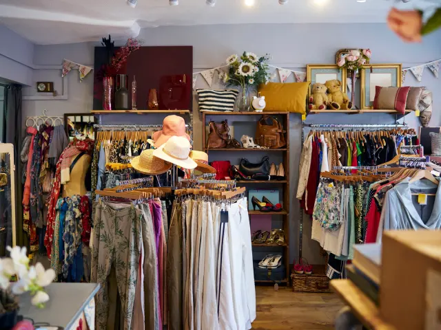 Racks of clothing and handbags inside a thrift store